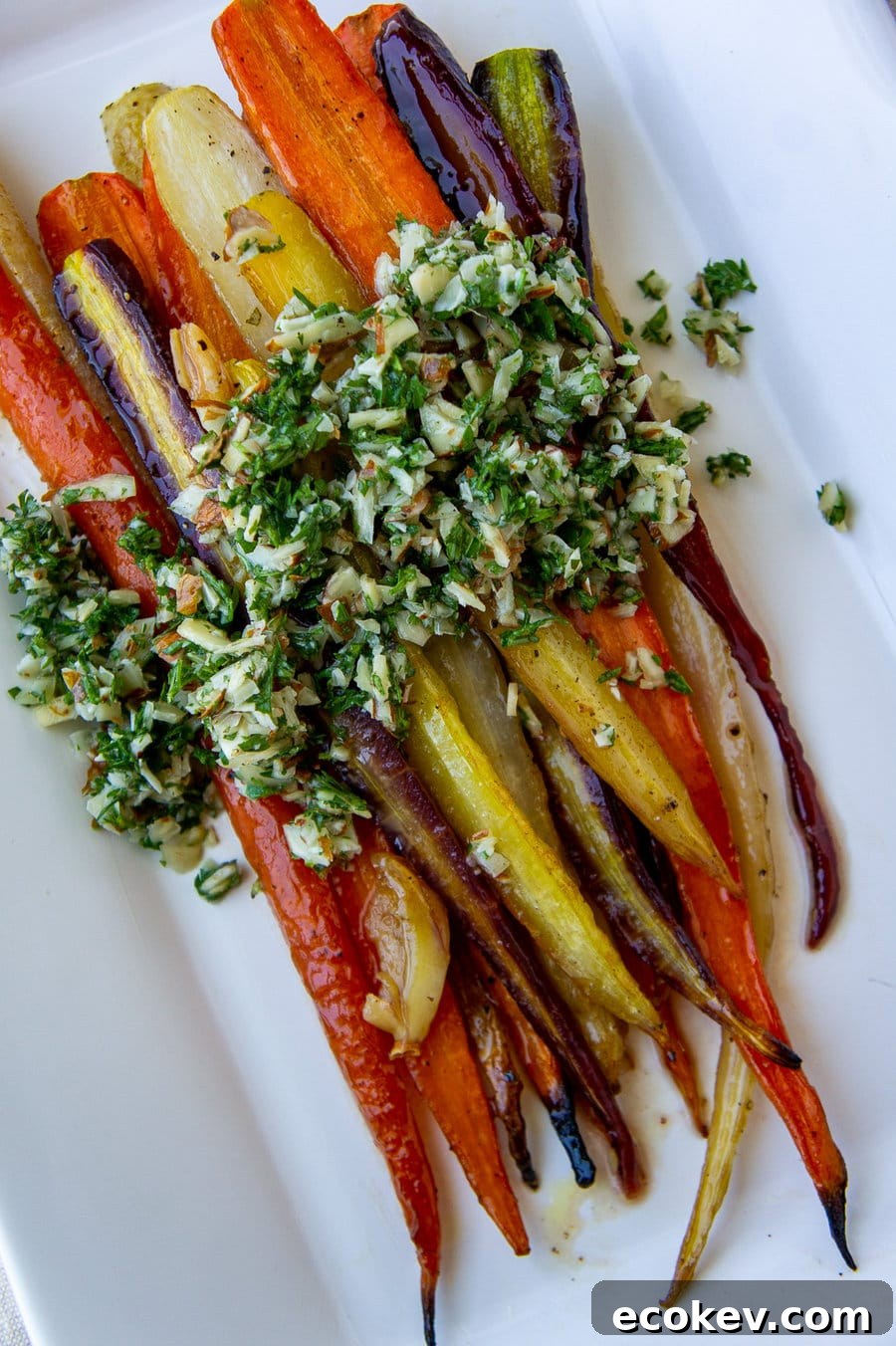 a platter of roasted glazed rainbow carrots topped with gremolata.