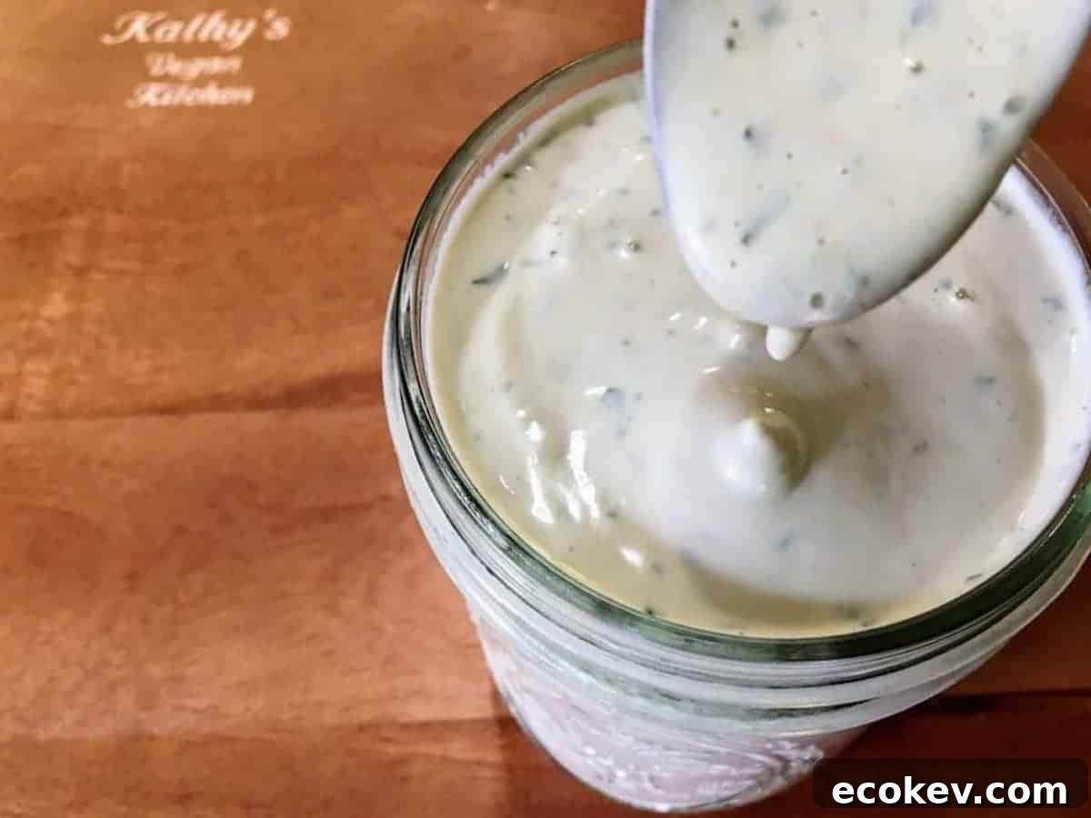 Vegan ranch dressing in a ball jar with a spoon.