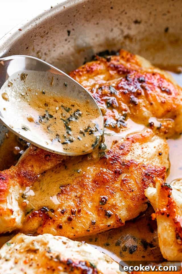 pouring butter and herb sauce over pan fried chicken