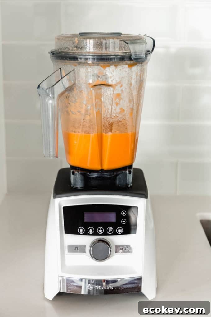 A blender with blended orange juice and ginger juice in it