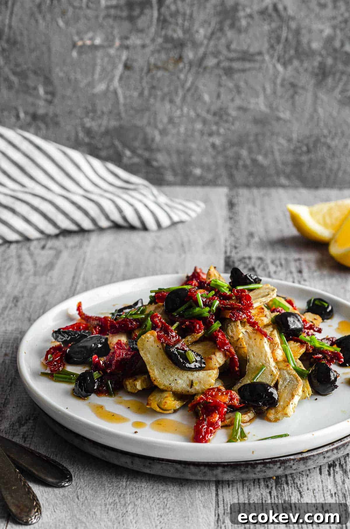 Side View of of a white plate with artichoke hearts salad