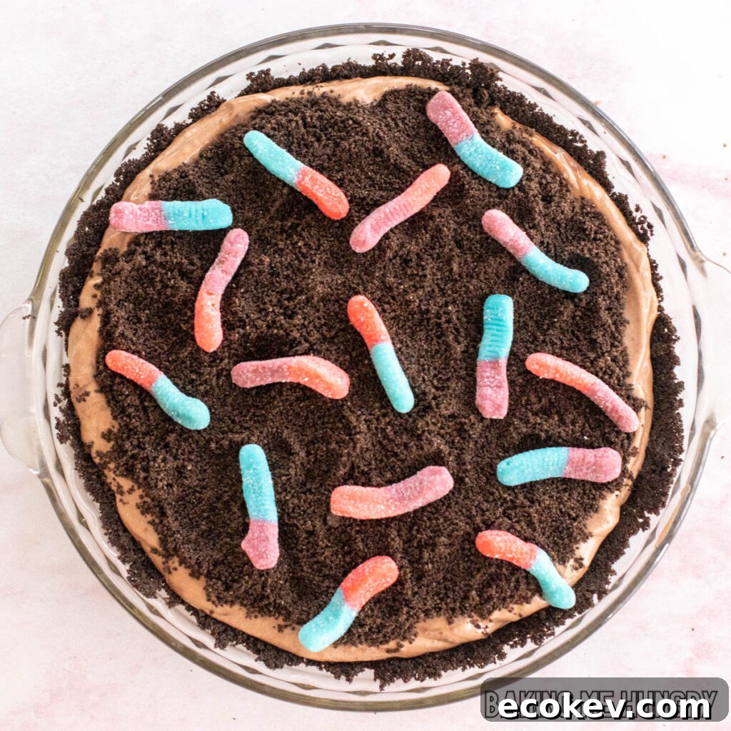 mud pie recipe with gummy worms shown from overhead in glass pie plate