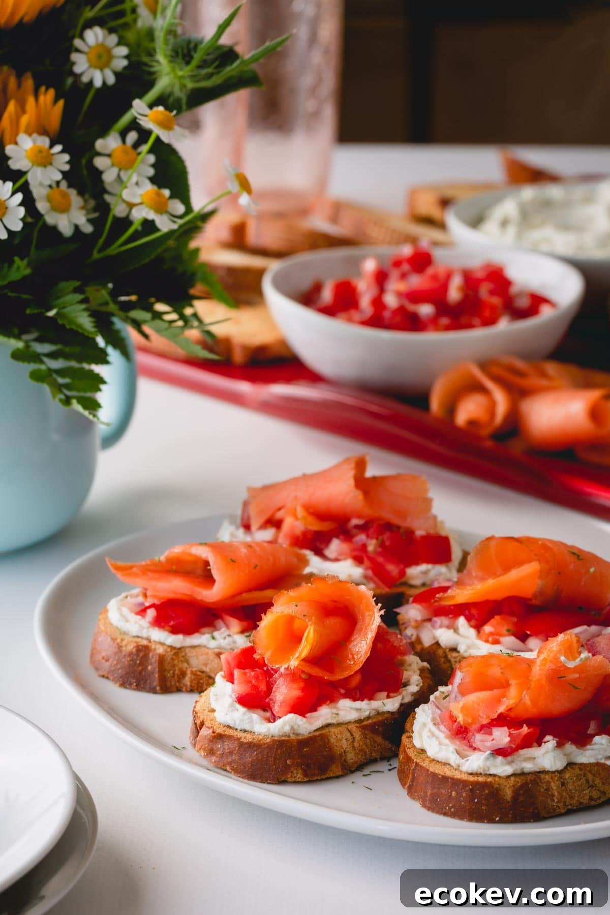 Assembled smoked salmon crostini on a white serving platter.