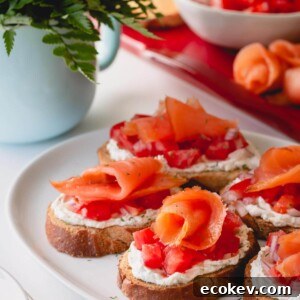 Assembled smoked salmon crostini on a white serving platter.