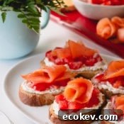Assembled smoked salmon crostini on a white serving platter.