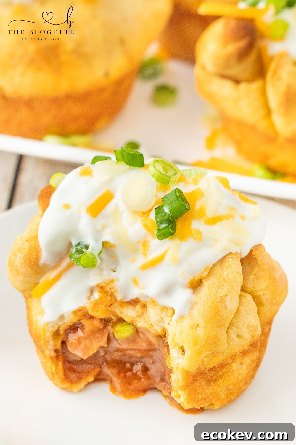 Chili stuffed rolls! Buttery biscuits surrounding chili and cheese, topped with sour cream and green onions. 