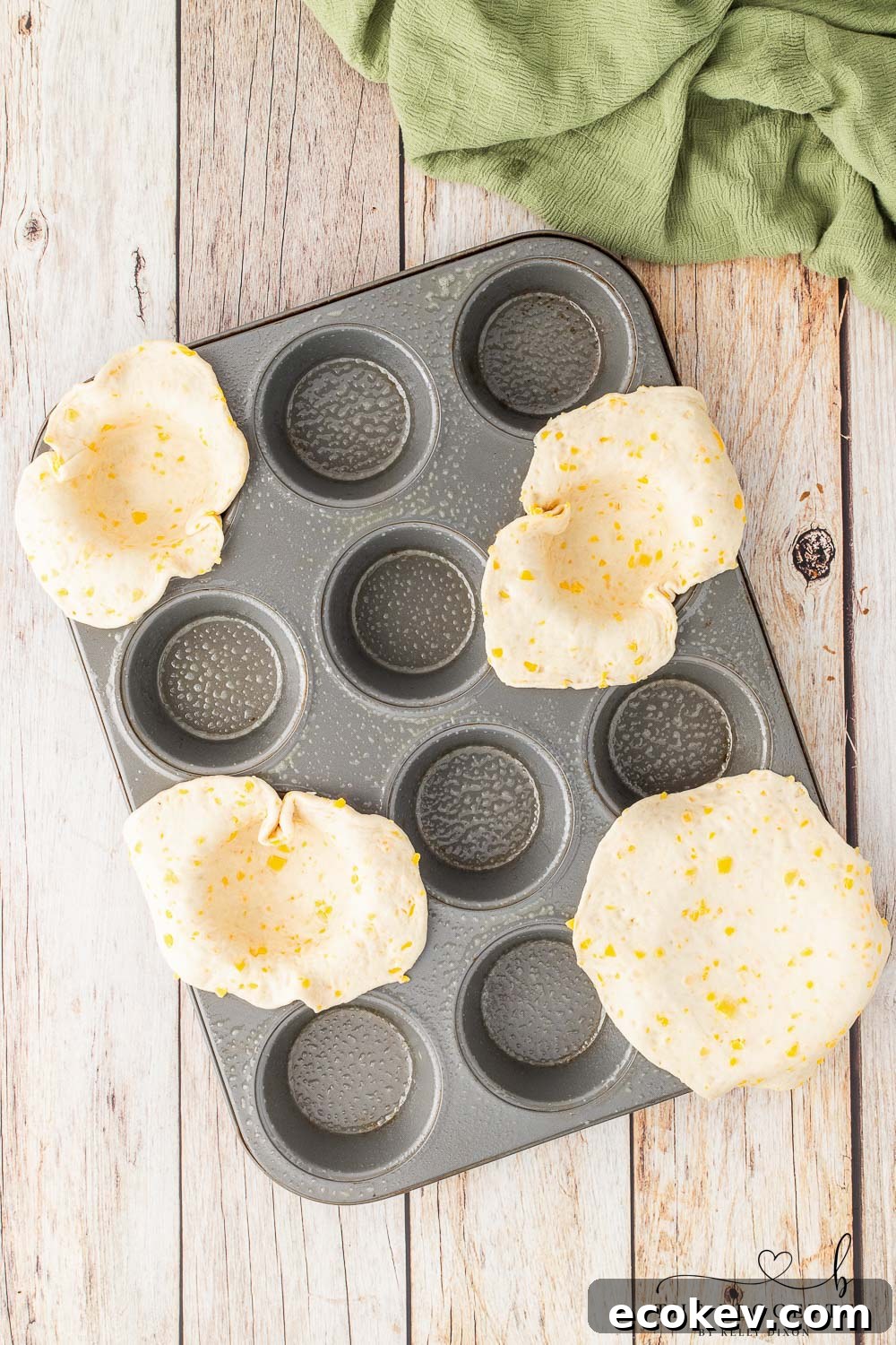Placed rolled out biscuits into muffin tin