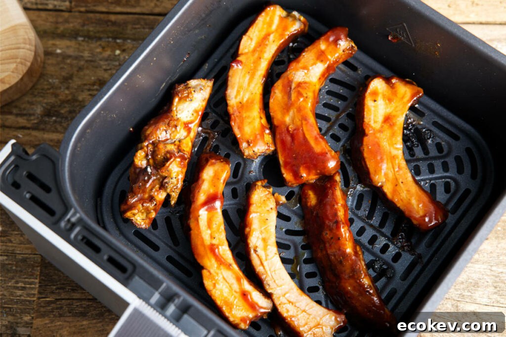 Sauce individual pork ribs in the air fryer basket.