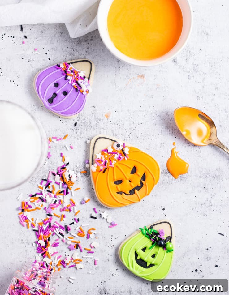 three treat bucket cookies on an off-white backdrop with sprinkles and icing along the sides