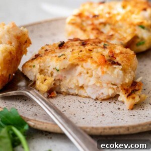 shrimp cake on a plate with a fork and a bite taken out