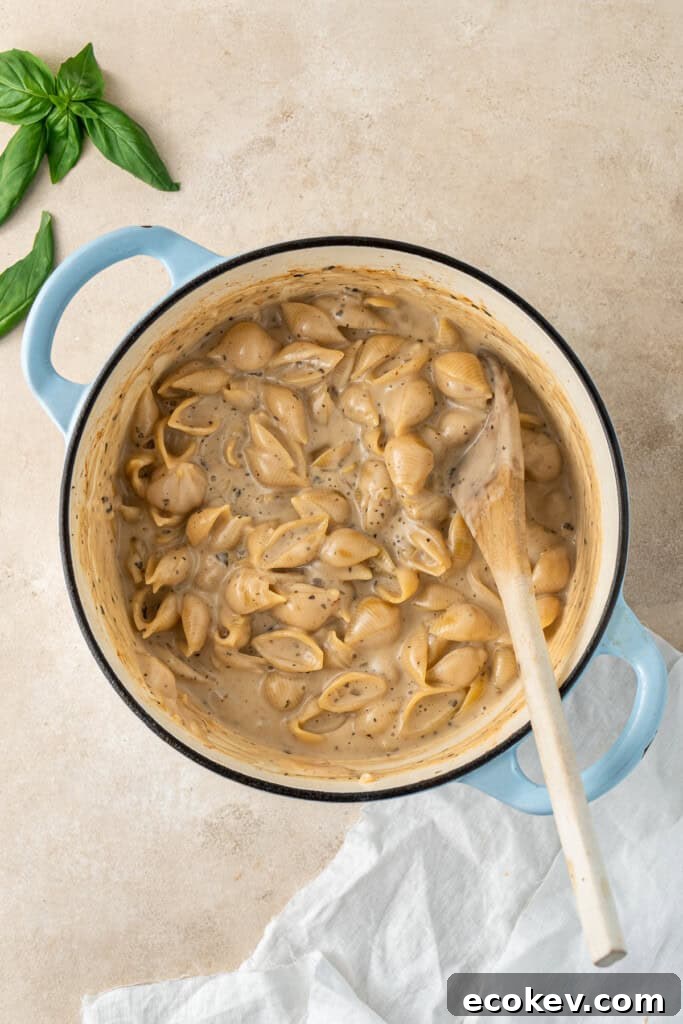 The pasta cooked in the creamy sauce in the pot.