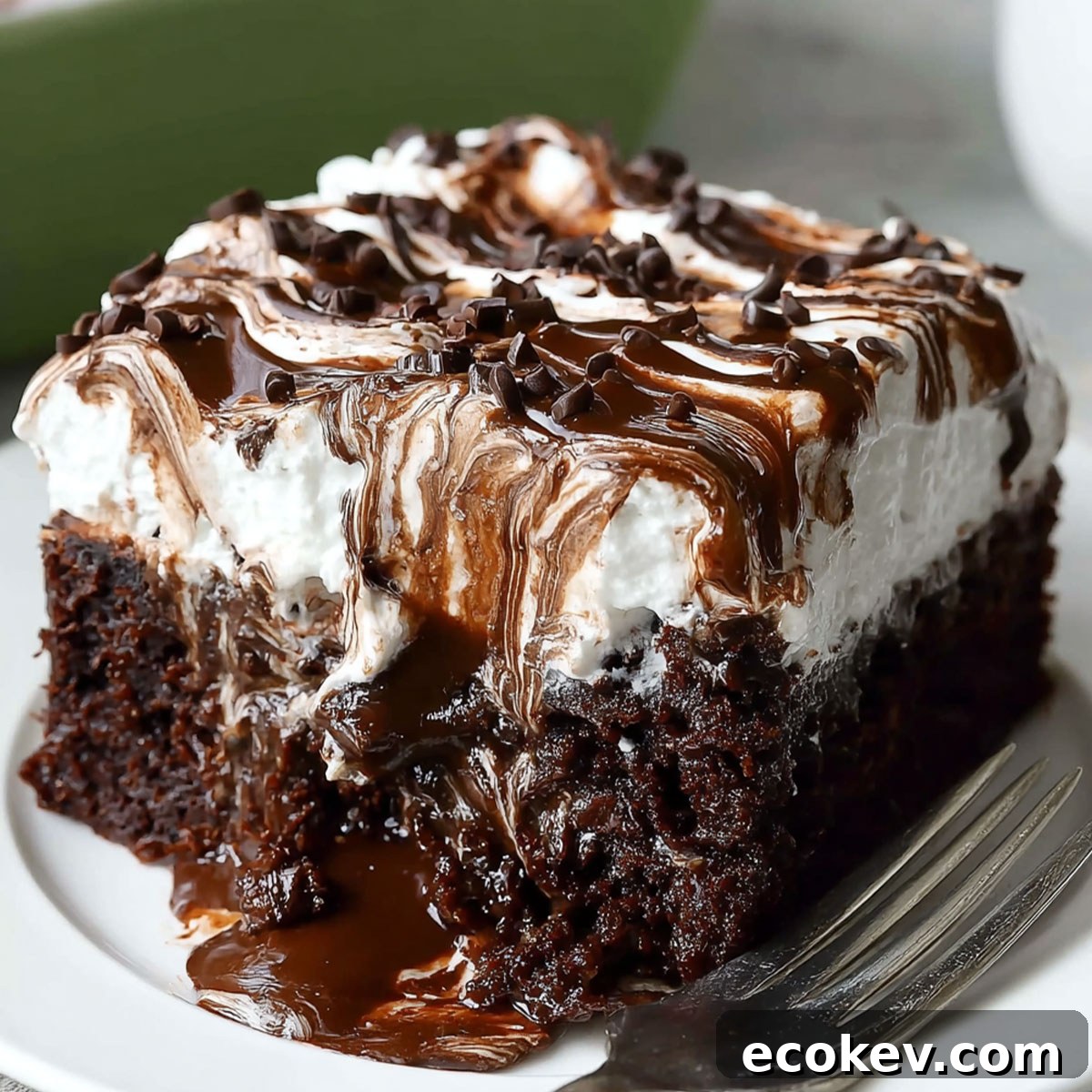 Chocolate Poke Cake with Marshmallow topping dripping with rich chocolate ganache and fluffy whipped cream