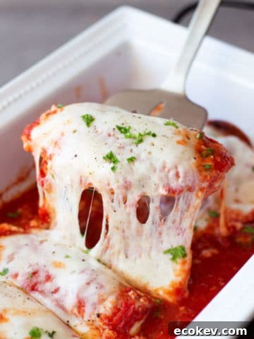 Spatula filled with chicken breasts topped with melted provolone cheese topped with fresh basil.