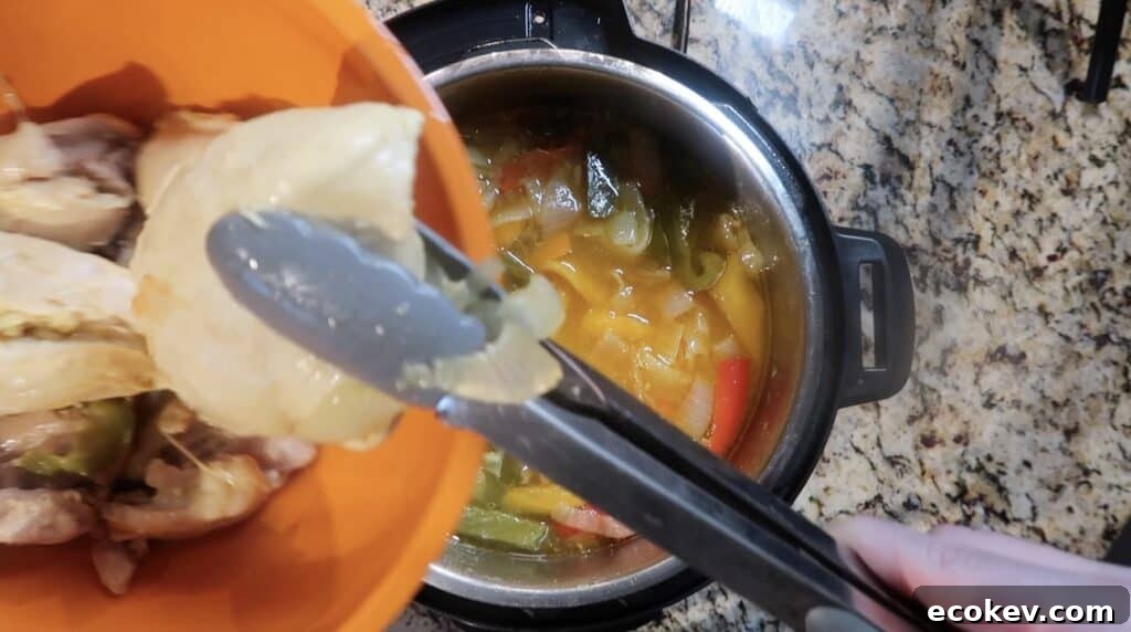 Using tongs to remove chicken from pot