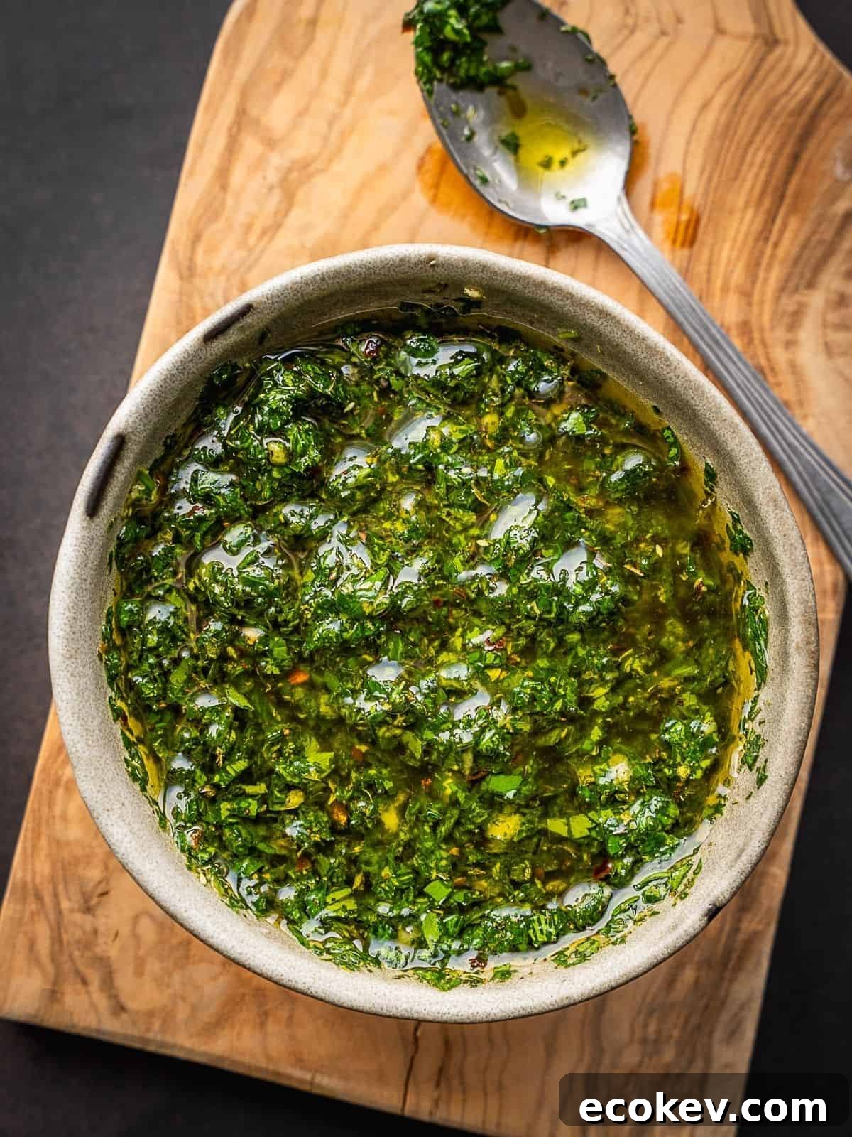 Mint chimichurri sauce in a bowl on a cutting board.