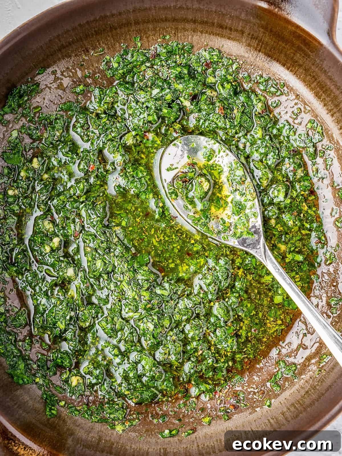 Mint chimichurri sauce getting mixed in a bowl.