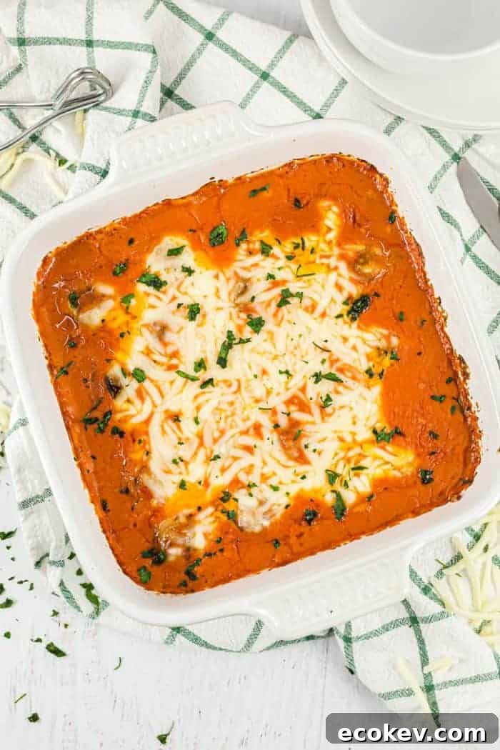 overhead view of keto meatball casserole in a white casserole dish next to dish towel