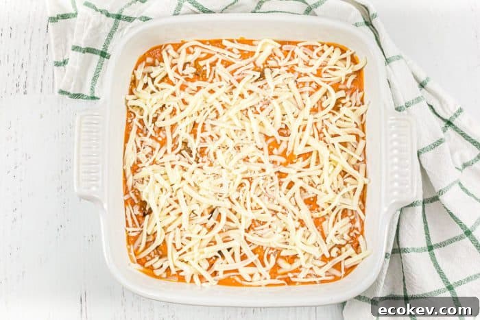 overhead view of keto meatball casserole covered with cheese before baking