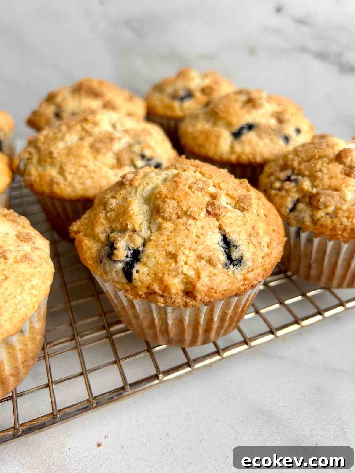 Fluffy Bisquick Muffins Recipe 2 muffins resting on wire rack.