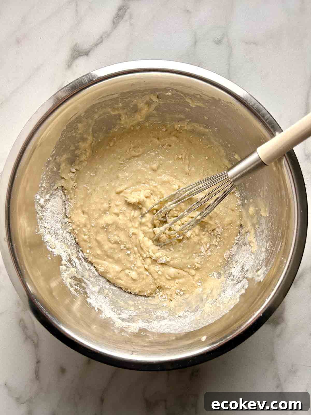 Fluffy Bisquick Muffins Recipe 4 wet and dry ingredients whisked together in bowl.